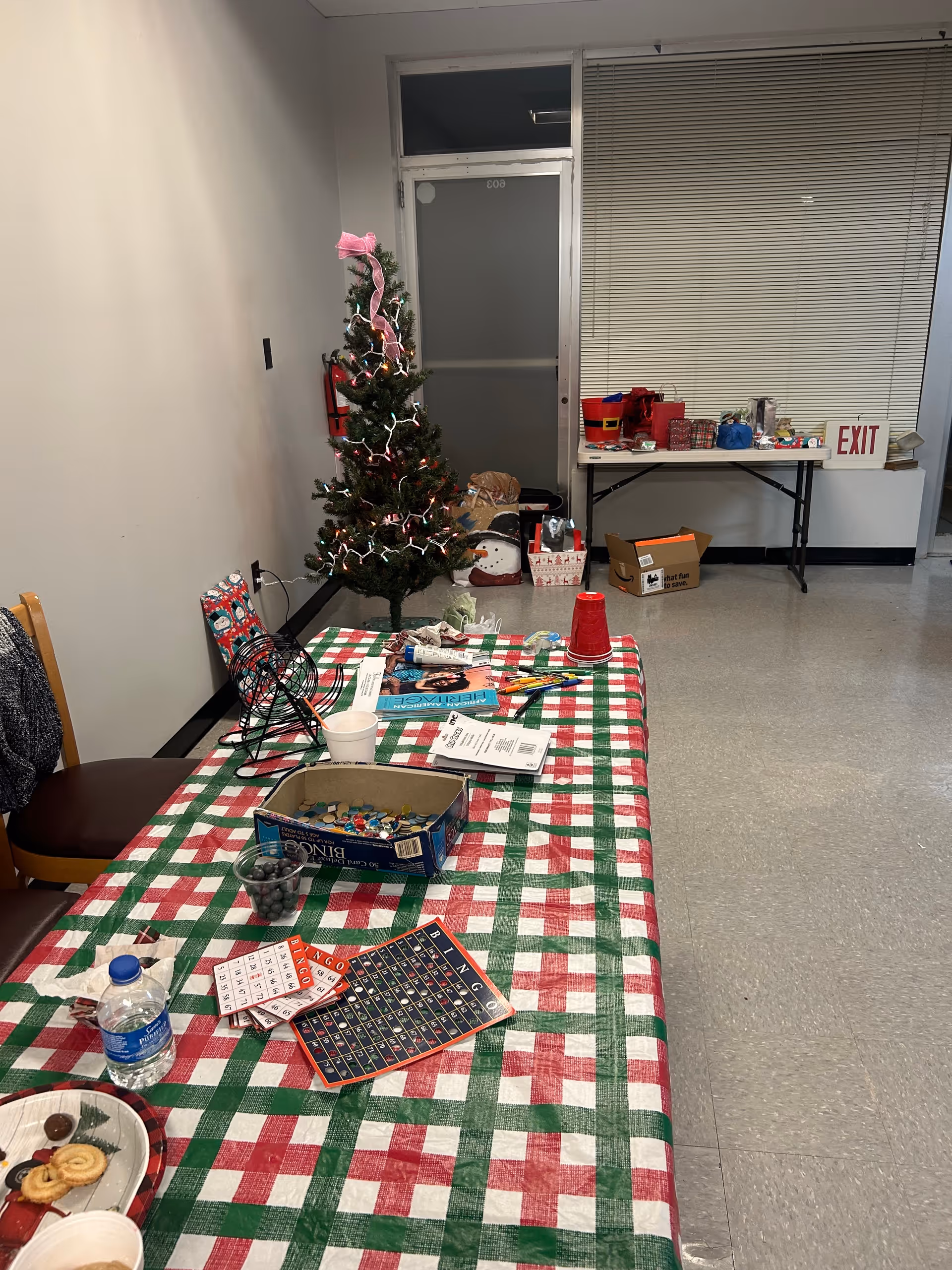 Interior activity room with a Christmas tree, table decorations, and craft supplies.