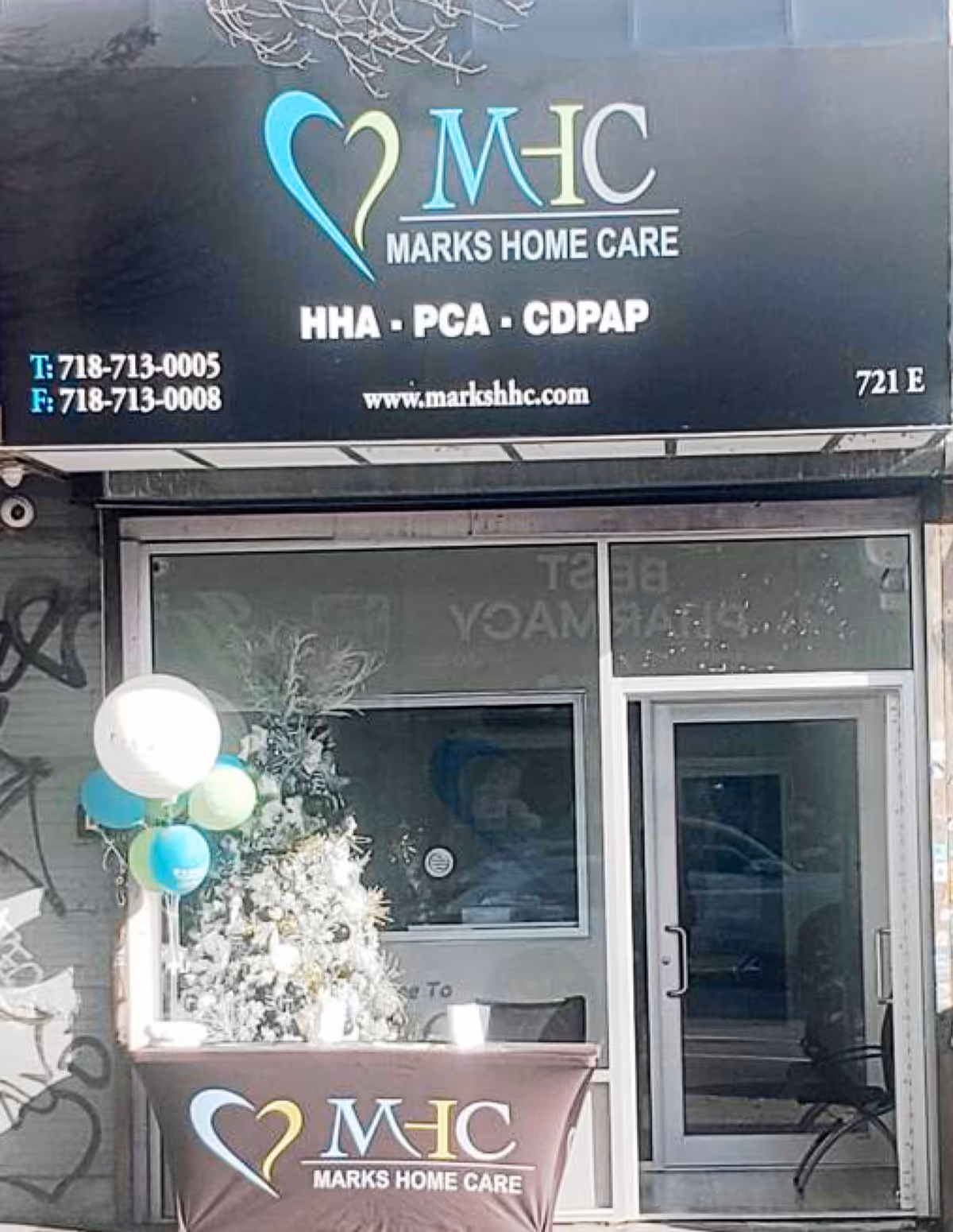 Front view of Marks Home Care storefront with balloons beside the glass entrance.