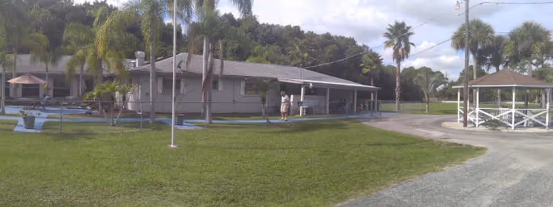 Single-story assisted living facility exterior with a covered walkway and gazebo.