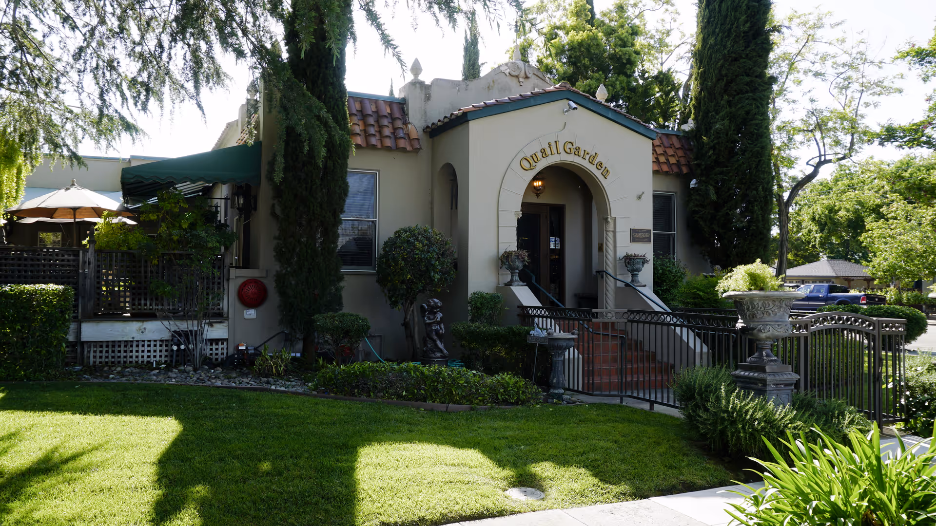 Front exterior view of Quail Garden senior facility with entry stairs and surrounding greenery.