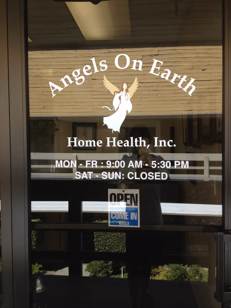 Glass entrance door with Angels On Earth Home Health signage and an OPEN sign.