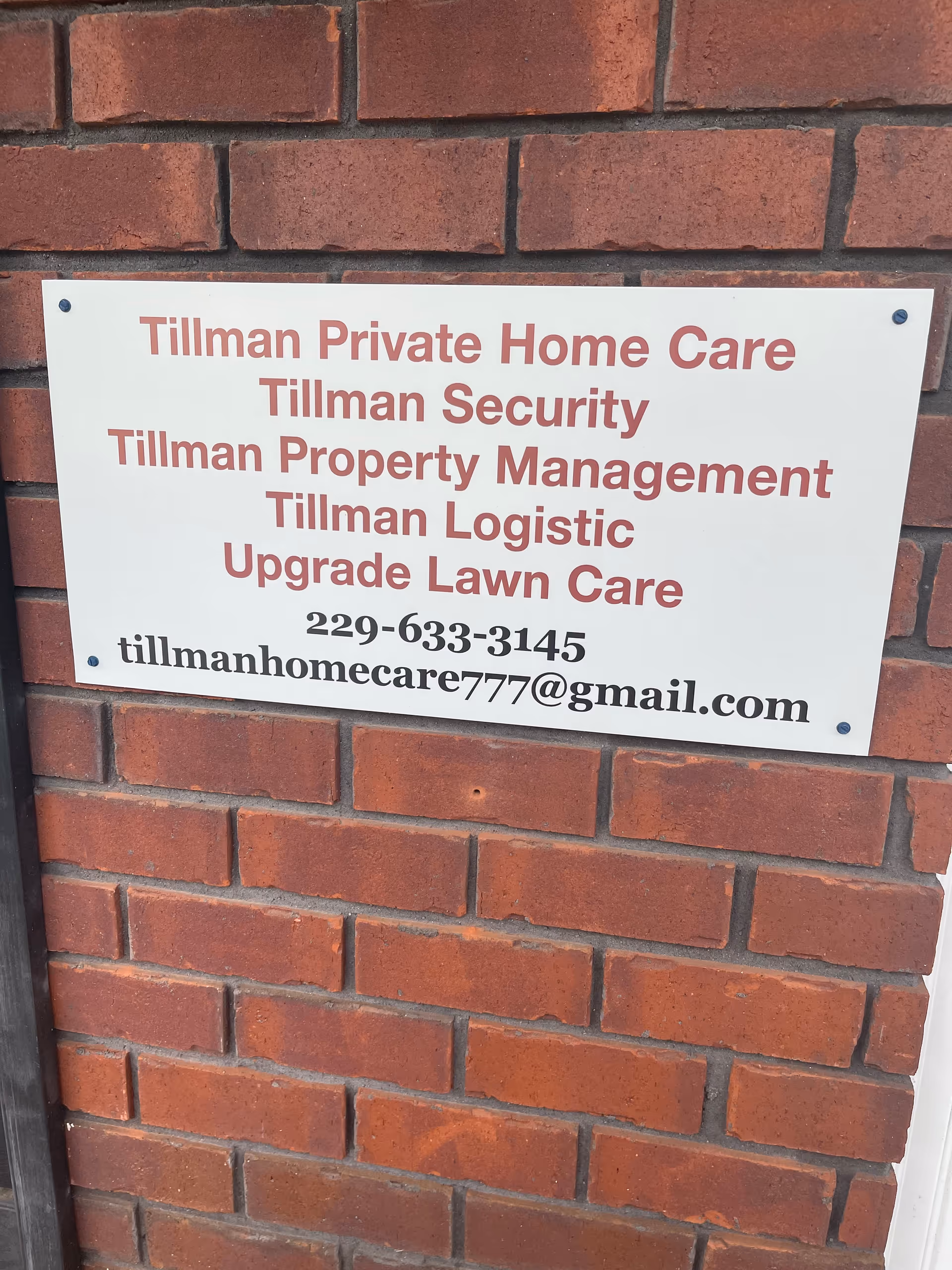 Sign on brick wall advertising Tillman Private Home Care LLC and services.