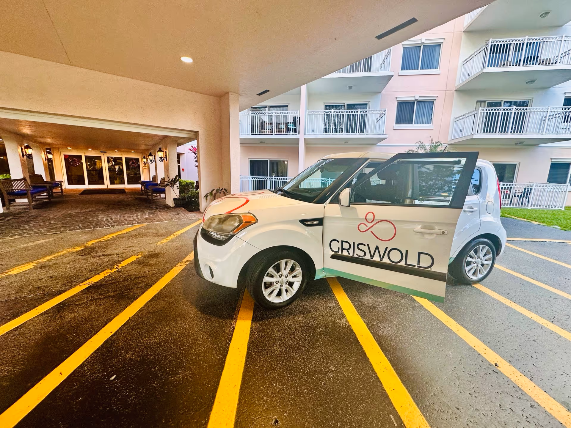 White Griswold-branded car parked under a covered entrance of a senior living building