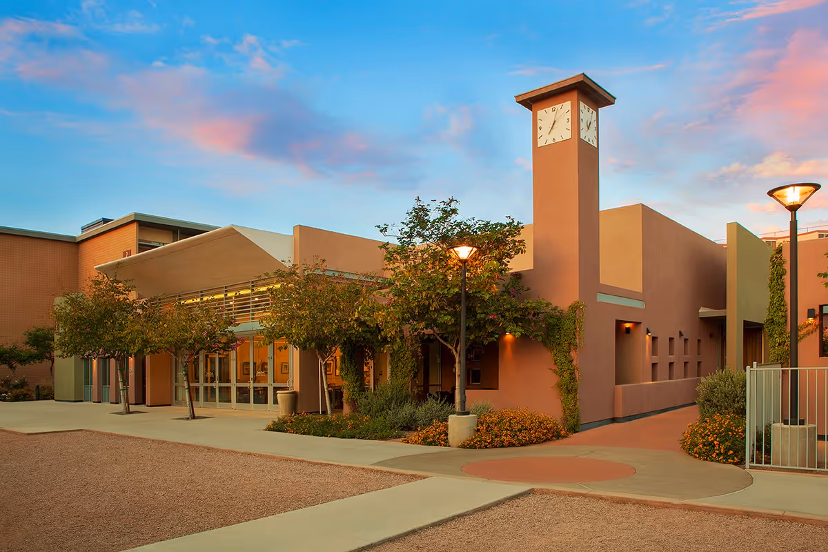 Exterior view of Beatitudes Campus building with clock tower, entrance, and landscaped walkway.
