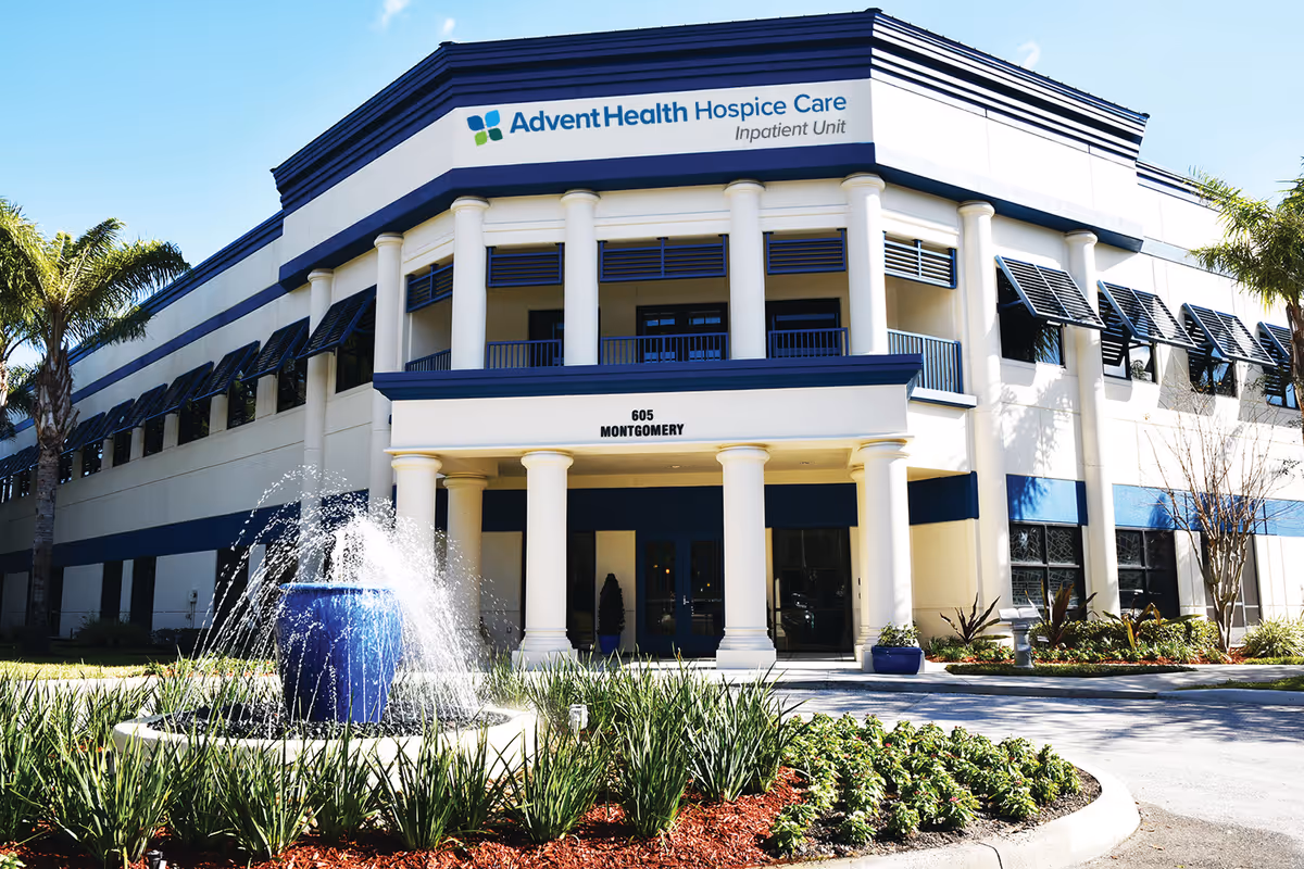 Exterior view of AdventHealth Hospice Care building with fountain and landscaping.