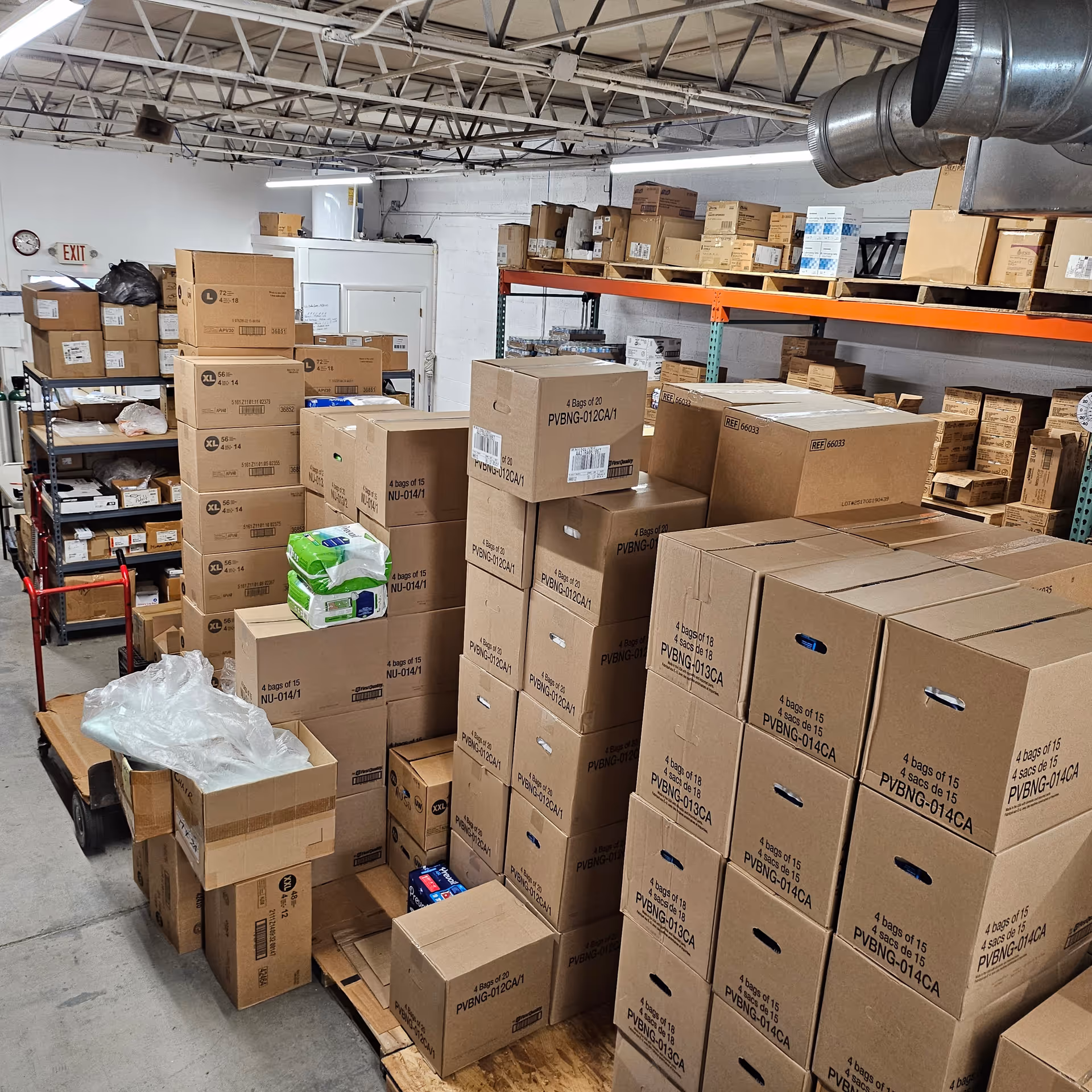 Warehouse storage room filled with stacked boxes and pallets in a medical supply facility.