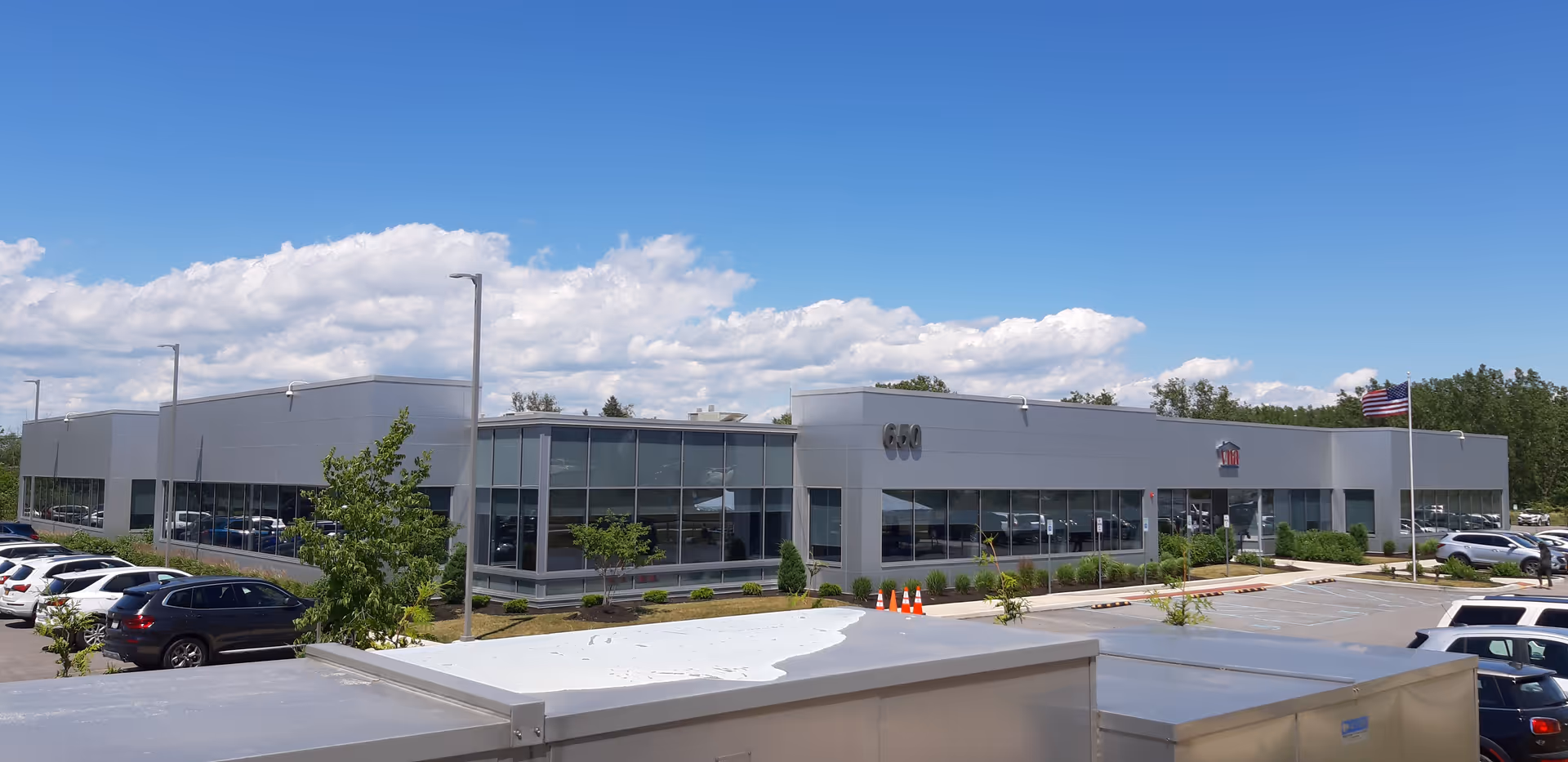 Modern single-story senior living center with glass walls and a parking lot.