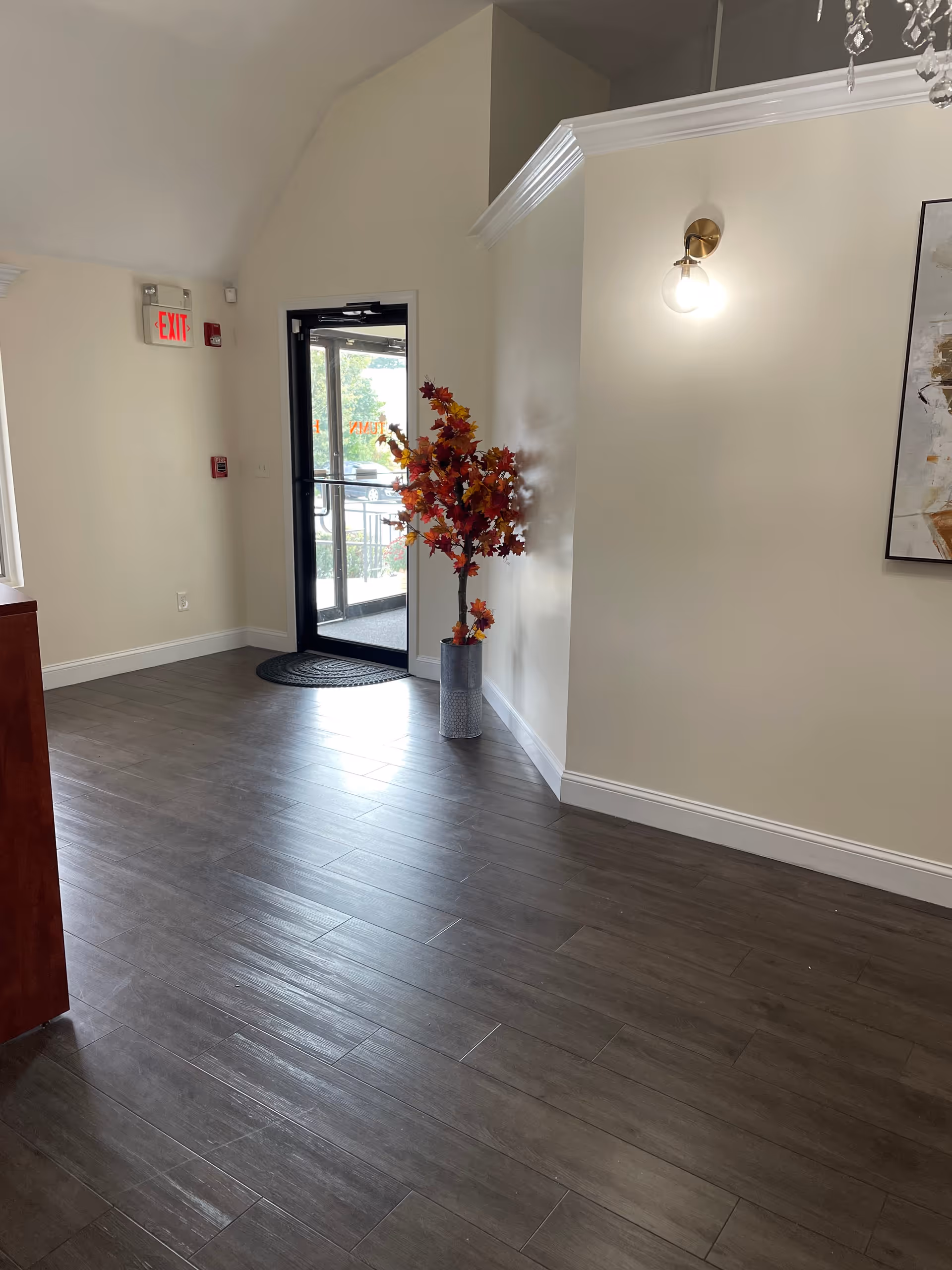 Interior hallway at Autumn Hospice with a decorative plant near the exit door.