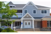 Front exterior of blue senior living facility named Country Club Retirement Campus with stairs.