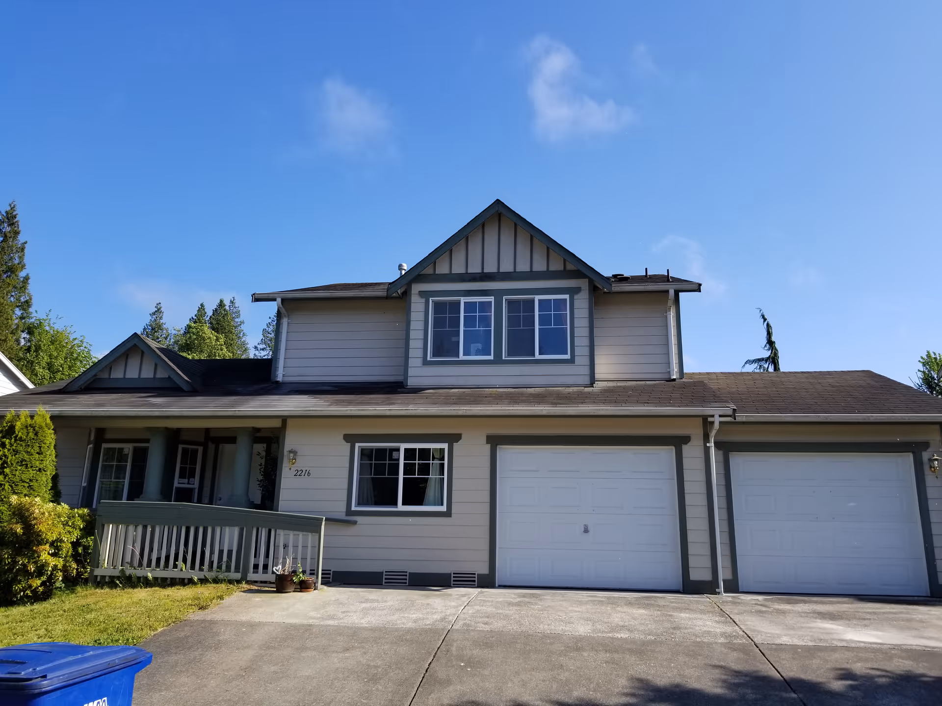 Residential two-story house with front porch and two-car garage.