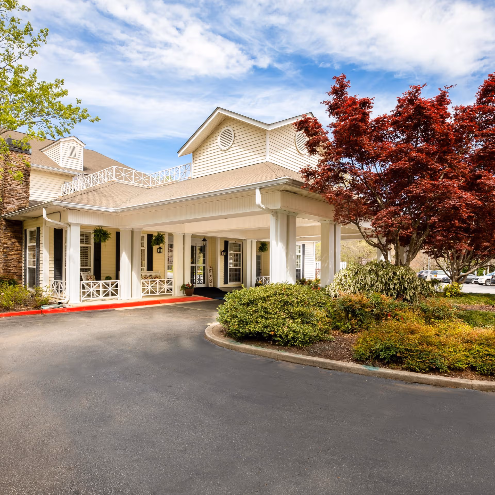 Arbor Terrace Athens senior living building exterior with a covered entrance and landscaped driveway.