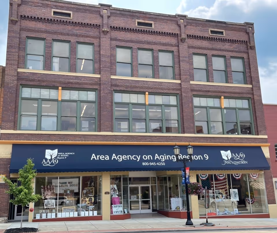Brick multi-story building with a blue storefront awning reading Area Agency on Aging Region 9
