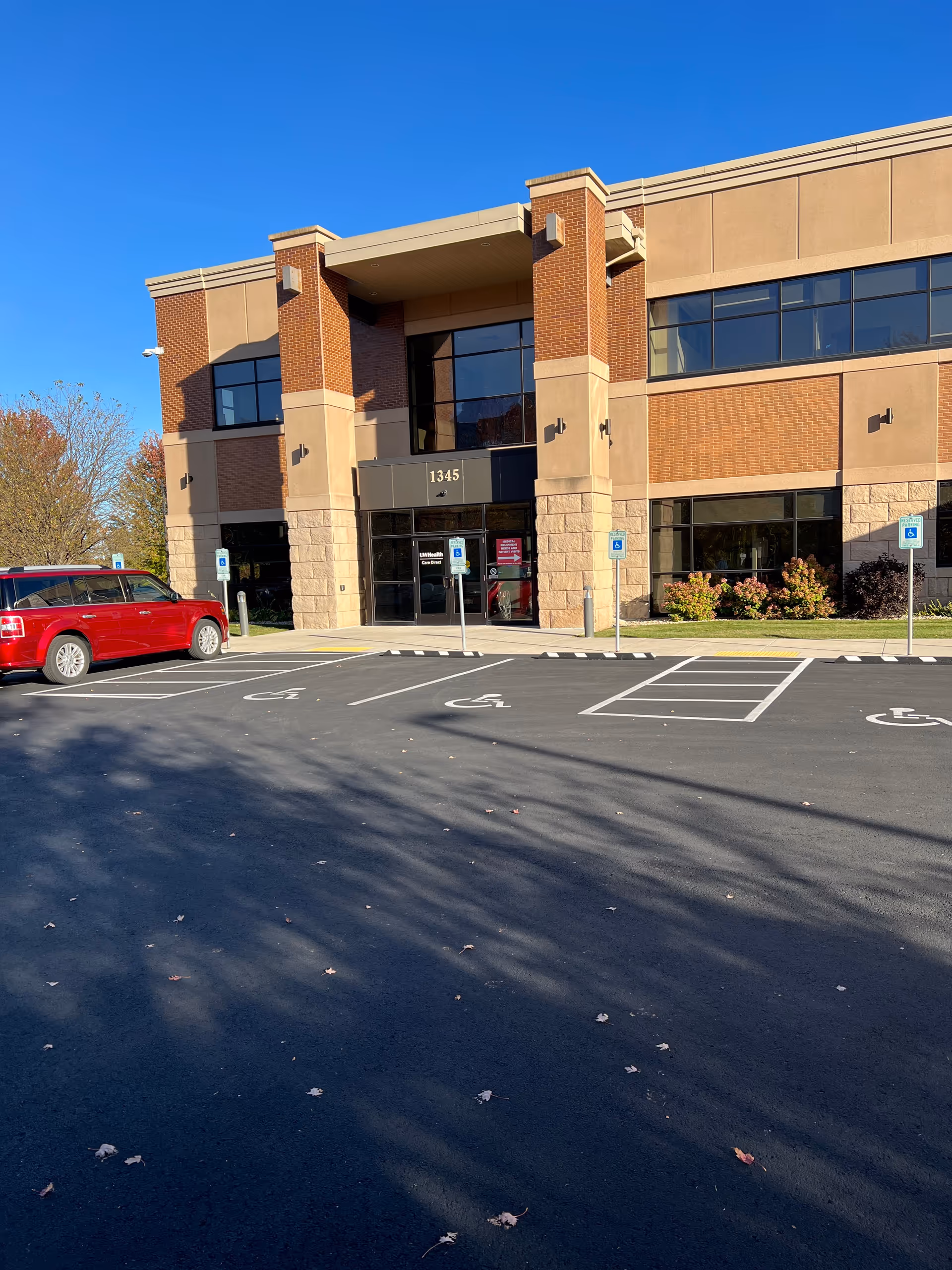 Facade of UW Health Care Direct building with brick pillars and accessible parking