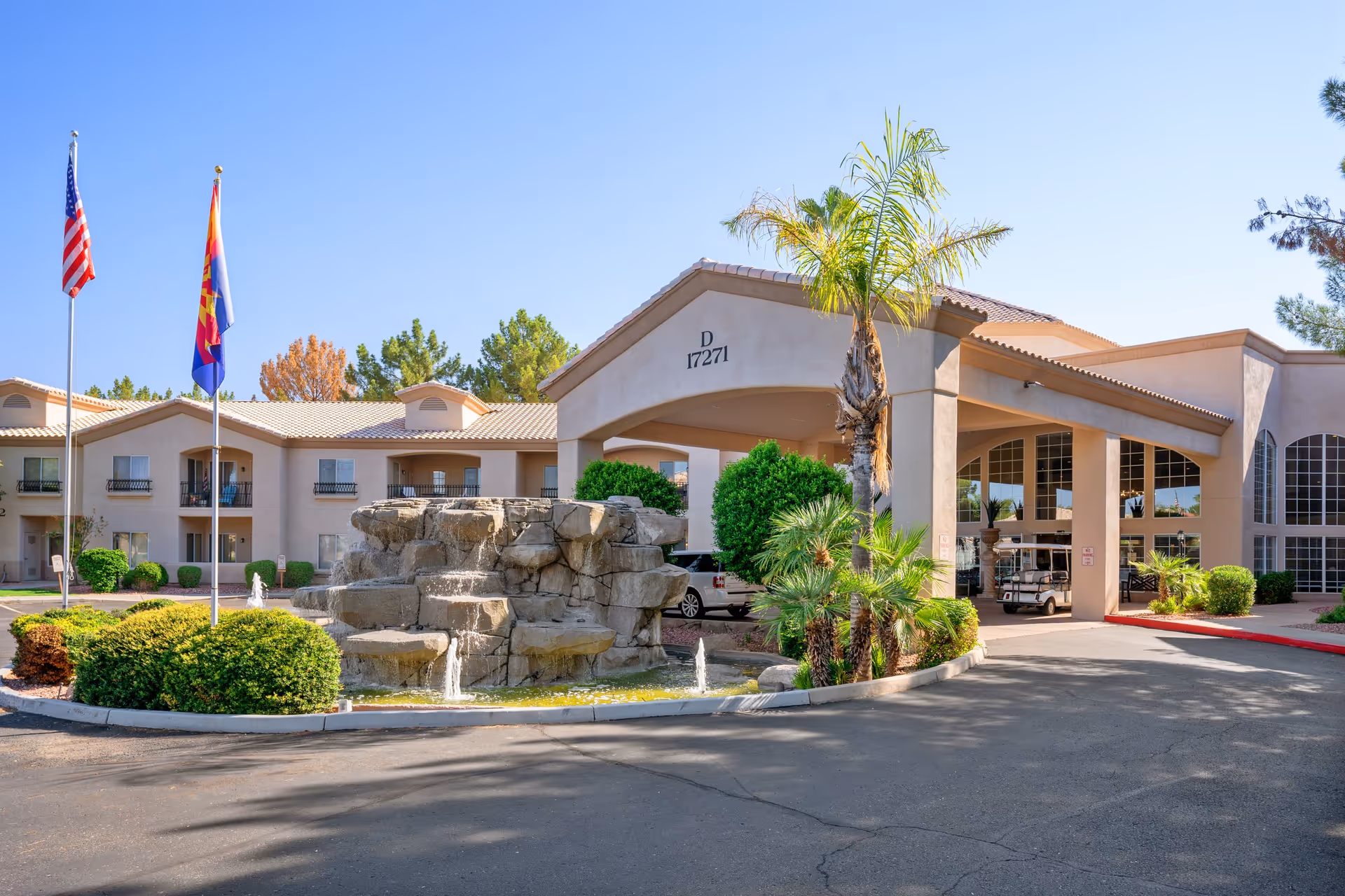 Exterior view of The Montecito Senior Living entrance with a fountain and flags.