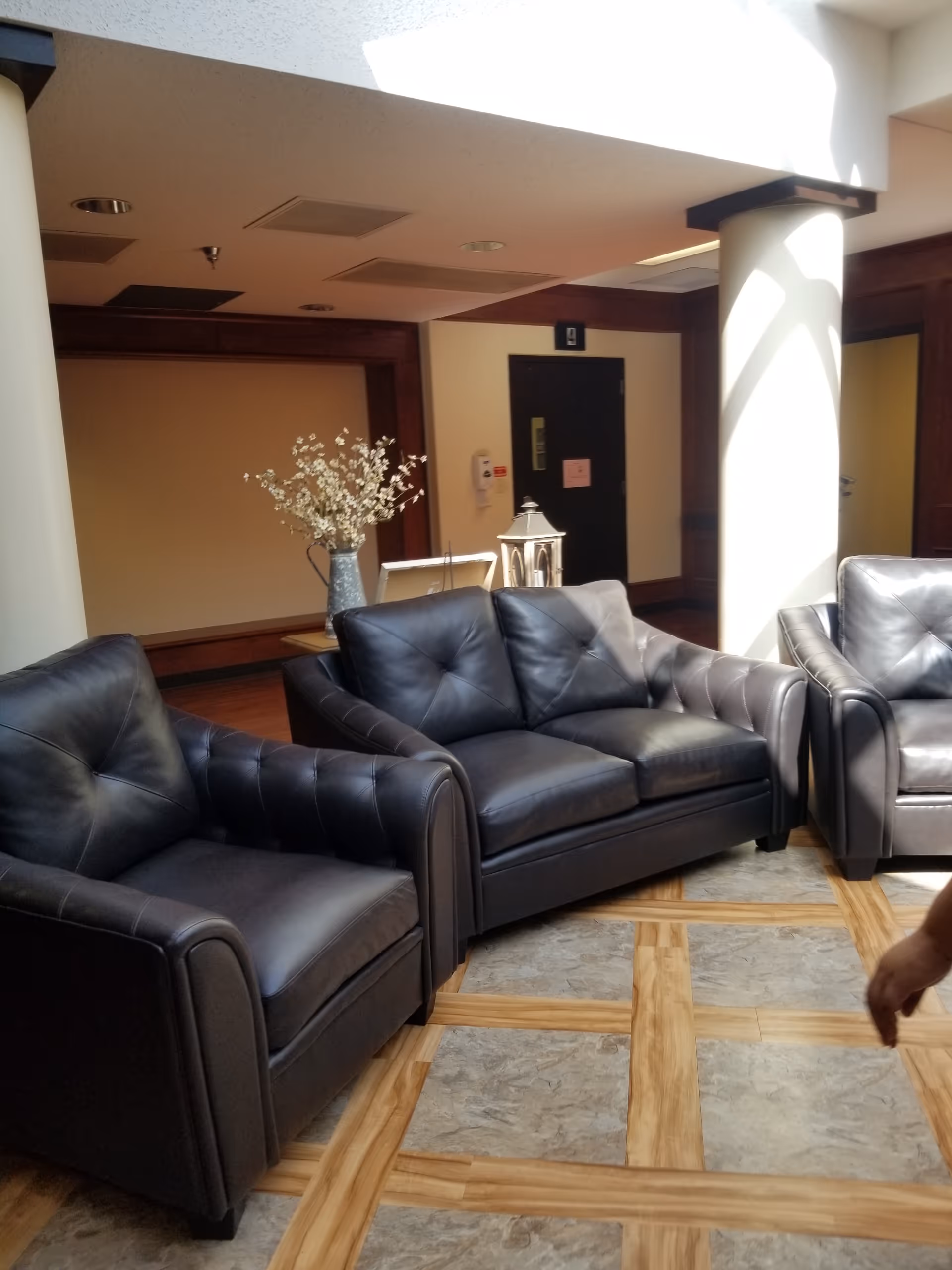 Lobby lounge at Windcrest Health & Rehabilitation with dark leather seating.