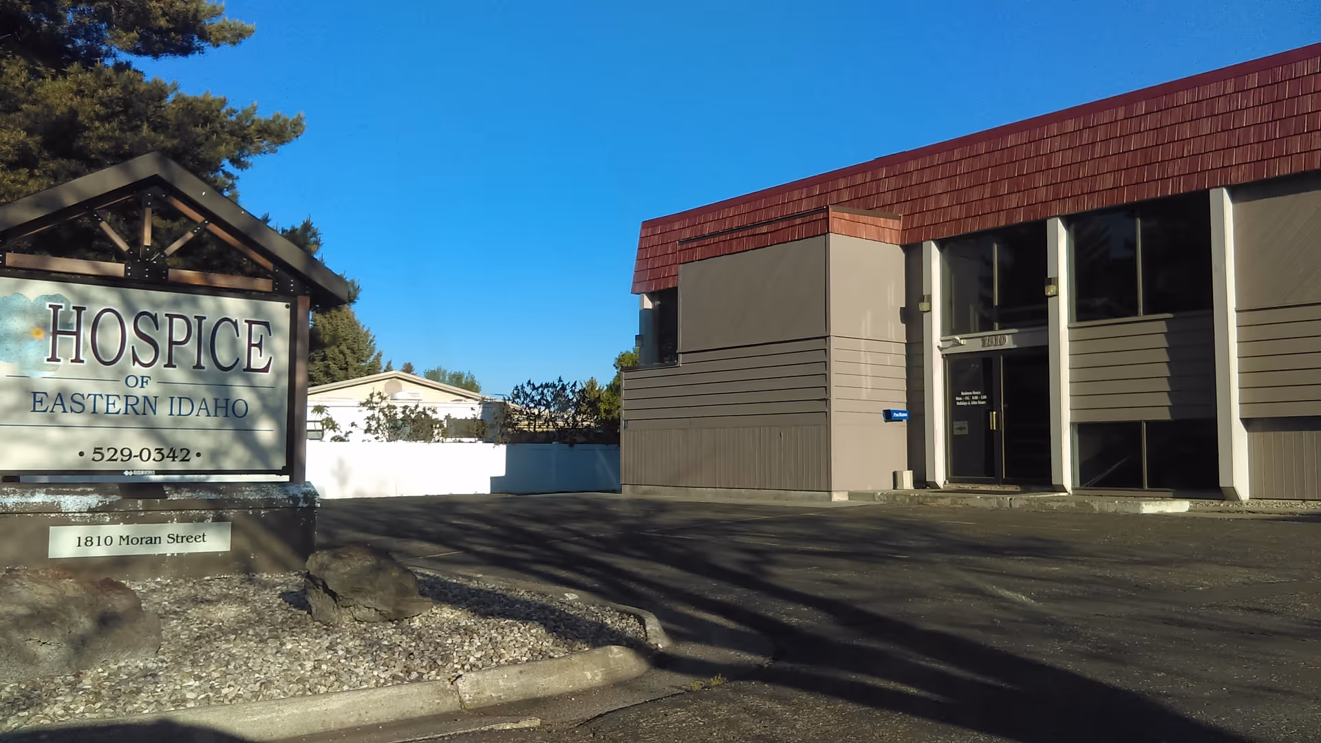 Exterior view of Hospice of Eastern Idaho building with sign and parking area.