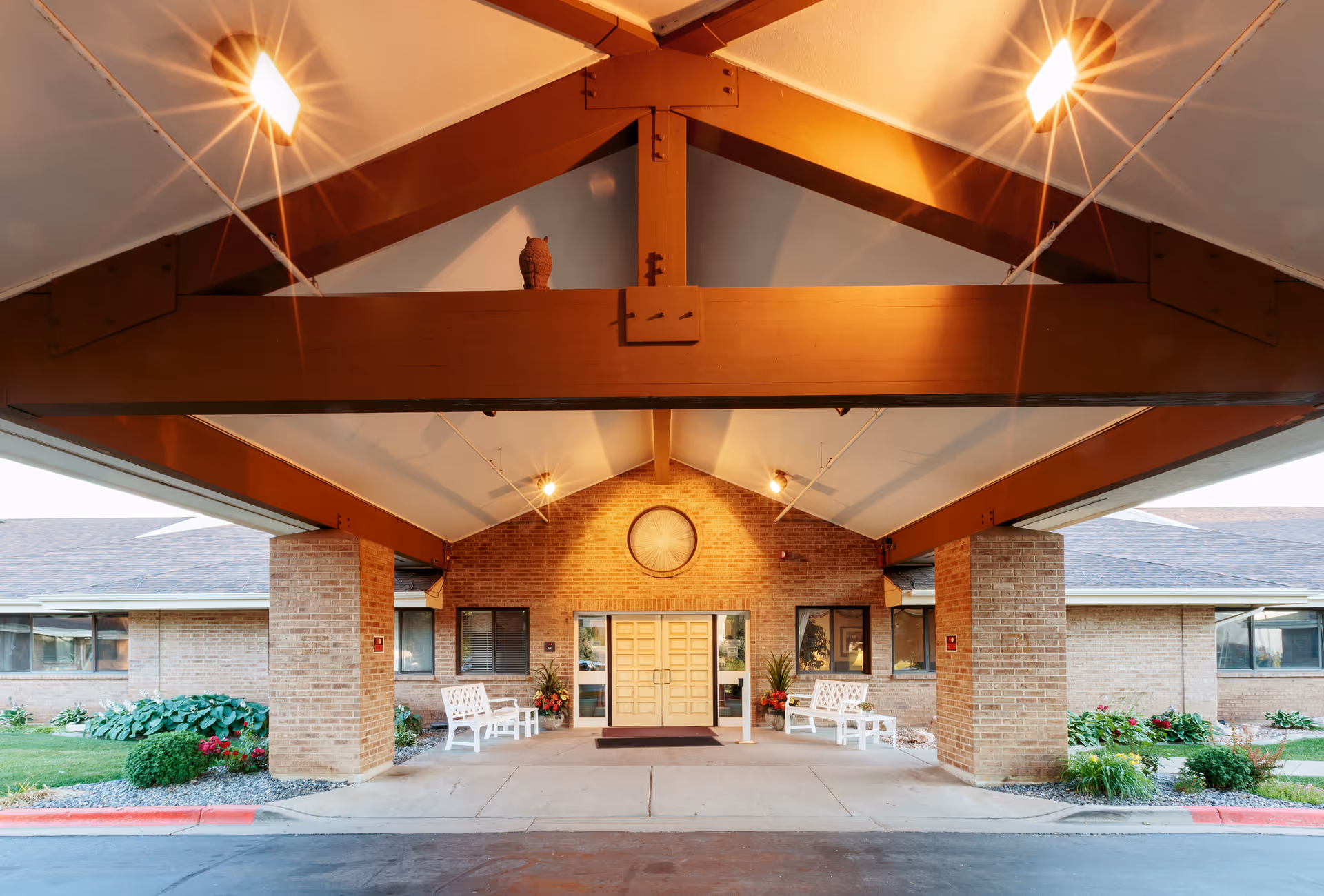 Front entrance of a senior living facility with brick columns and a large covered portico.