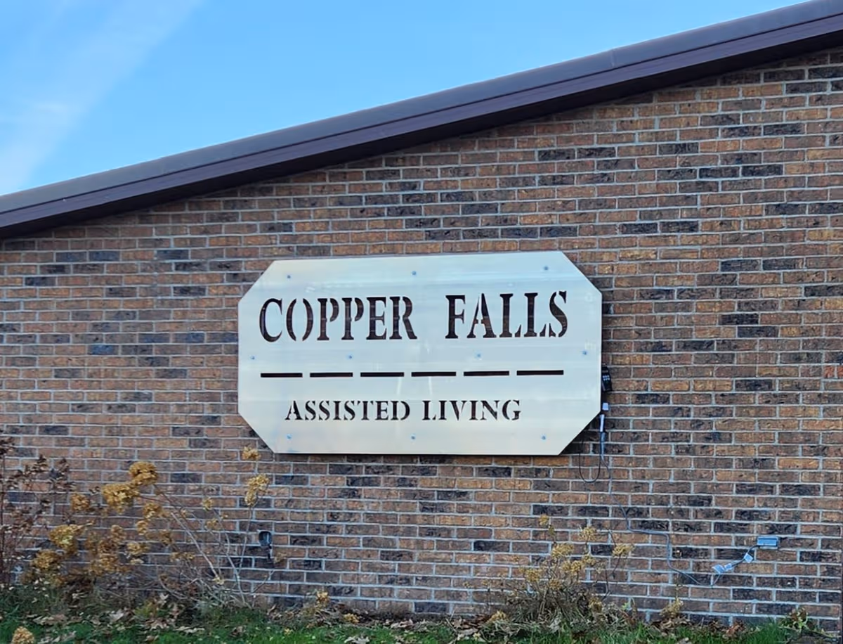 Copper Falls Assisted Living sign on brick exterior wall of a building