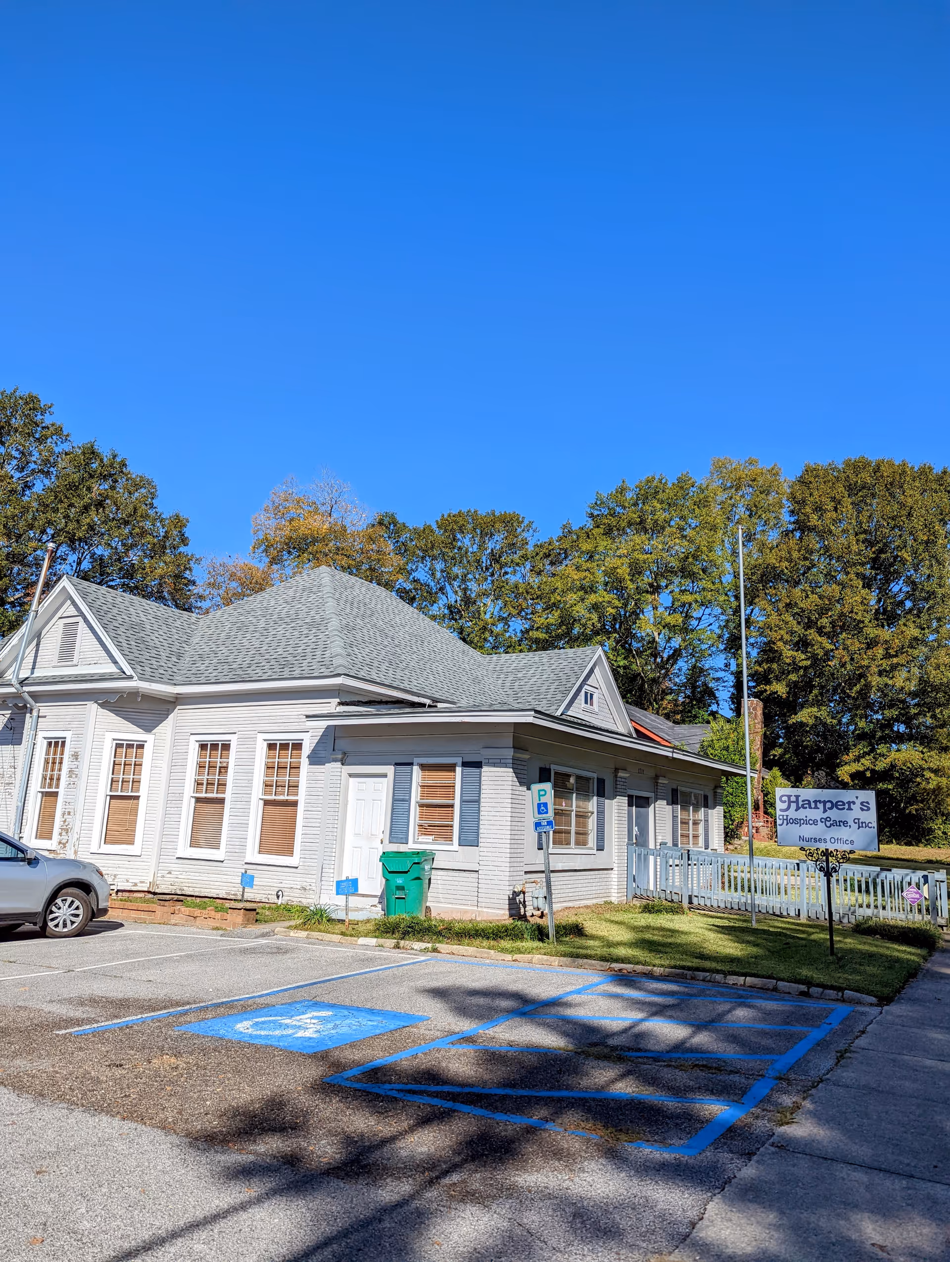 Exterior view of Harper's Hospice Care, Inc building with parking and blue sky.
