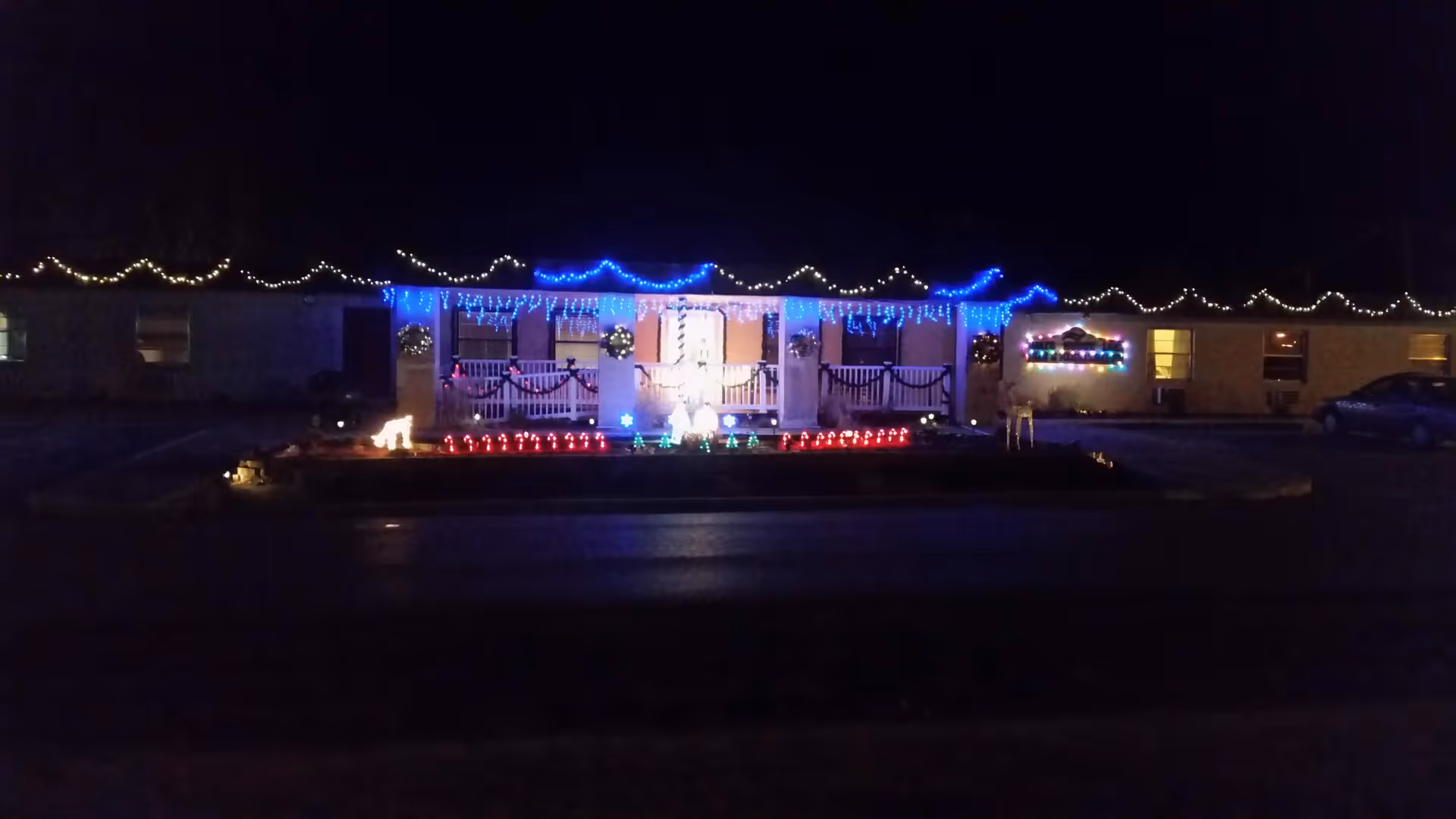 Night view of Hays House senior living facility with colorful string lights on the front porch.