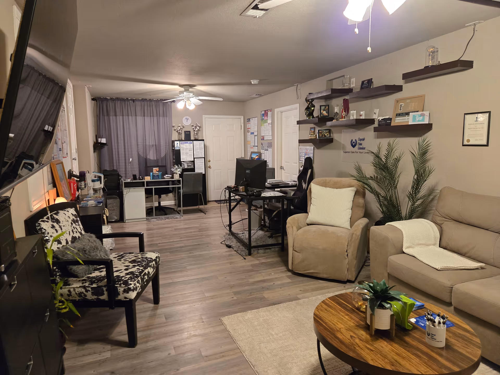 Cozy living room area with beige sofas, chairs, a wooden coffee table, and plants.