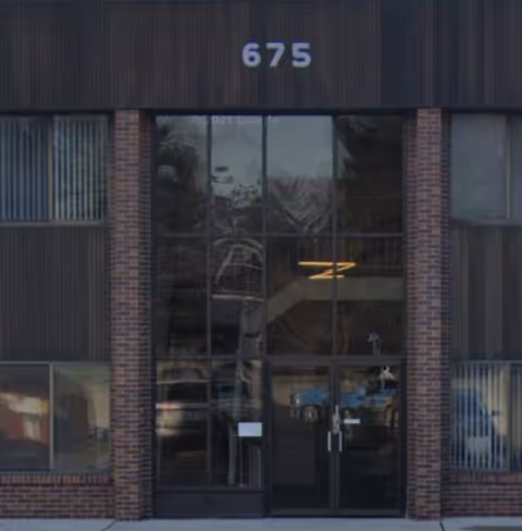 Entrance of Guardian Home Care of MI, a dark brick building with large glass doors.