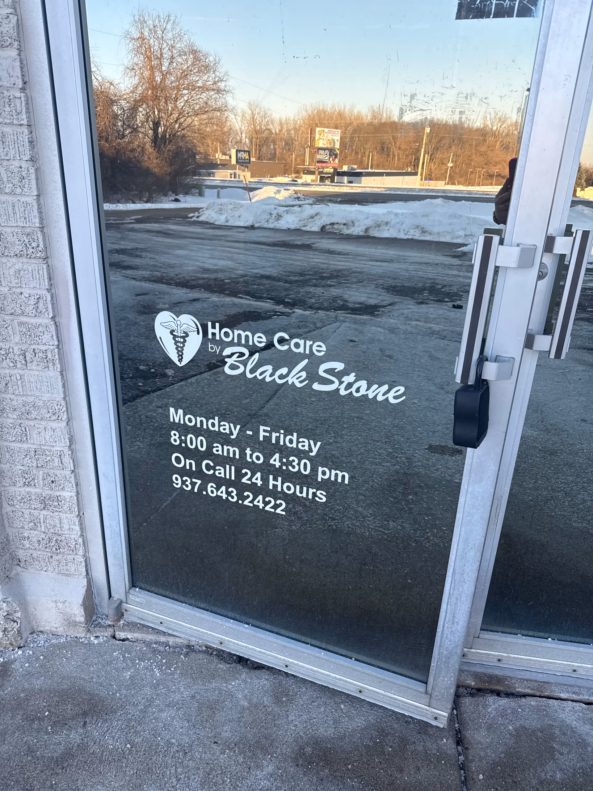 Glass door displays Home Care by Black Stone logo and hours.