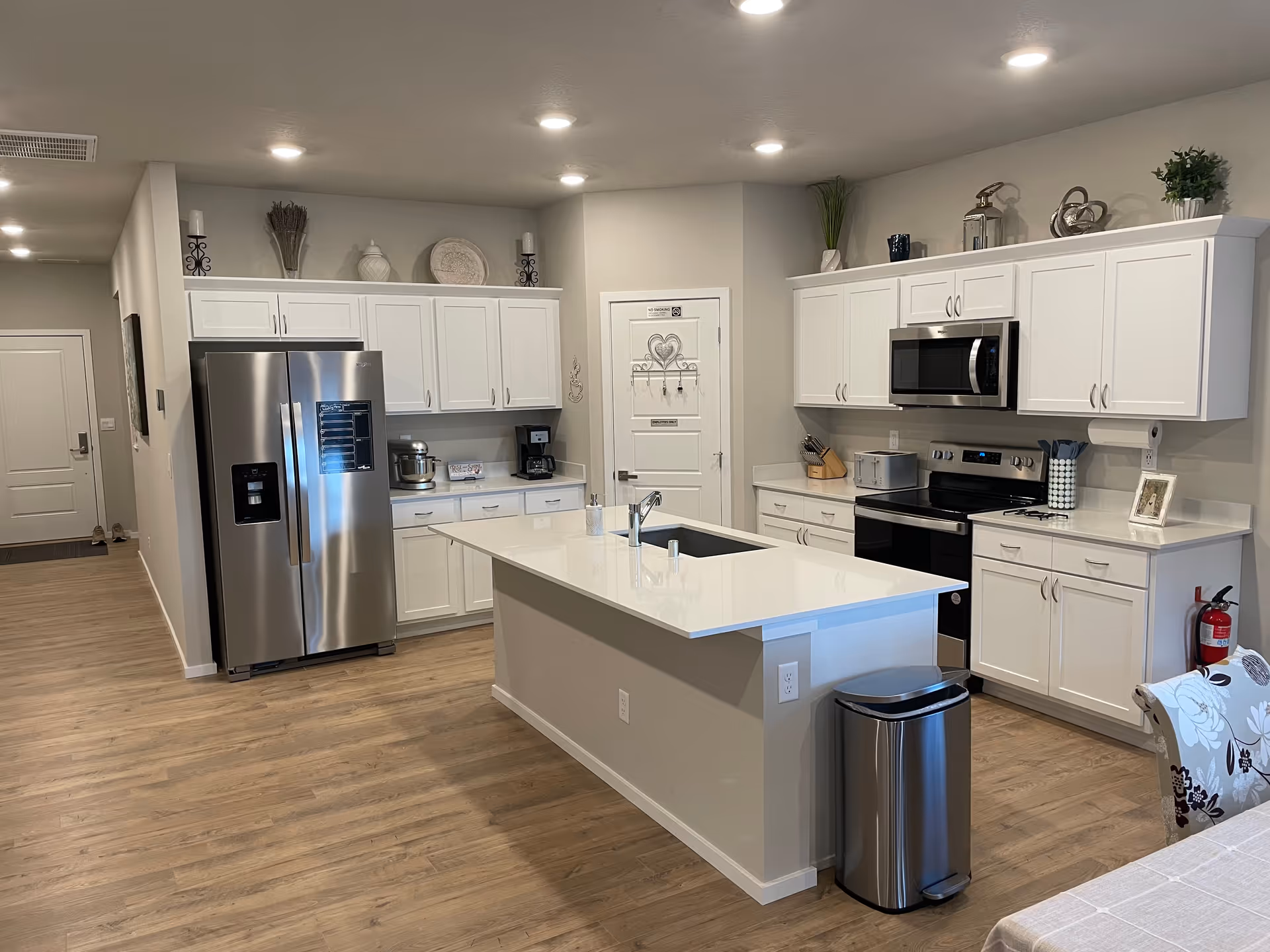 Bright, modern kitchen with white cabinets, stainless appliances, and a large island.