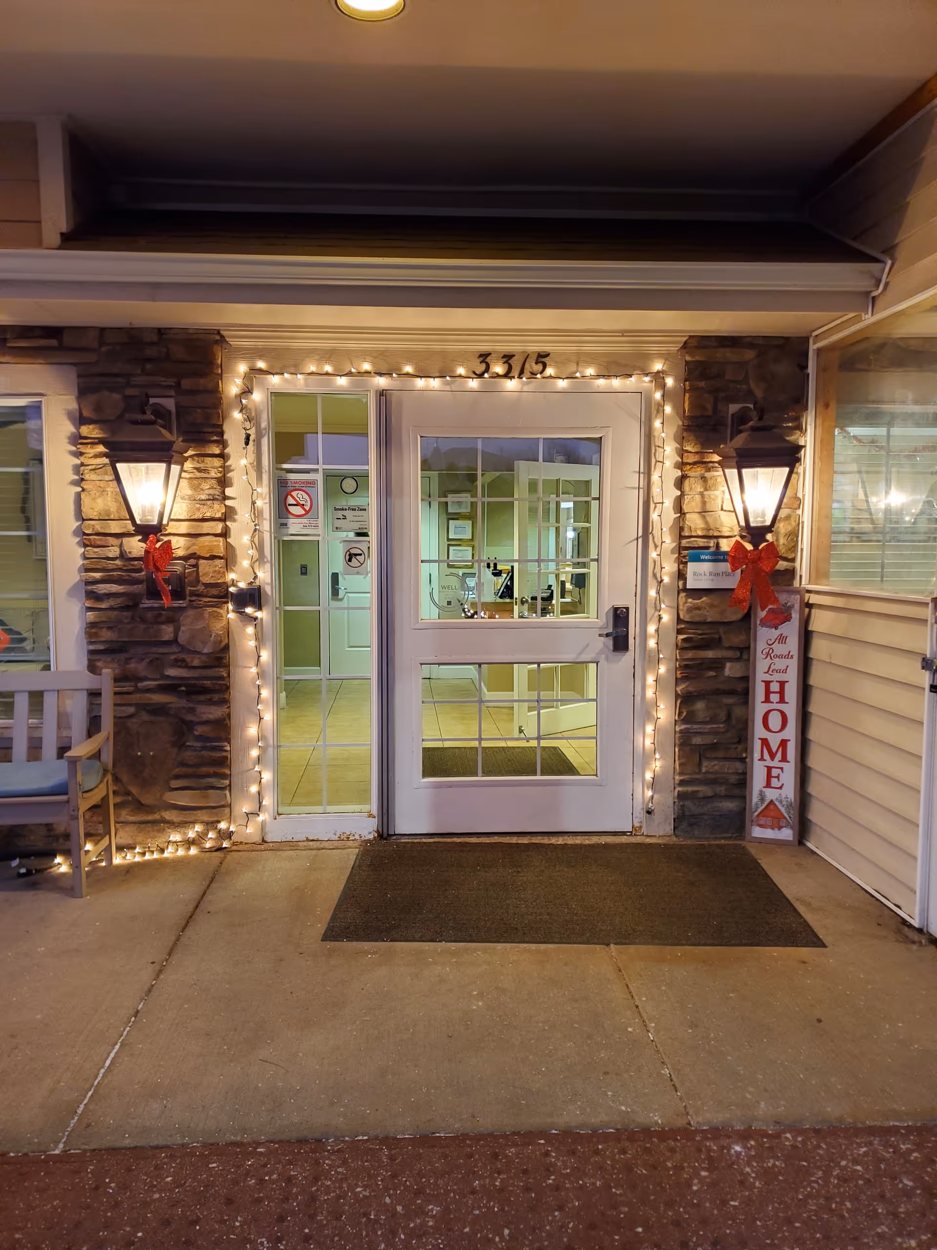 Exterior entrance of Rock Run Memory Care with lit doorway and stone accents