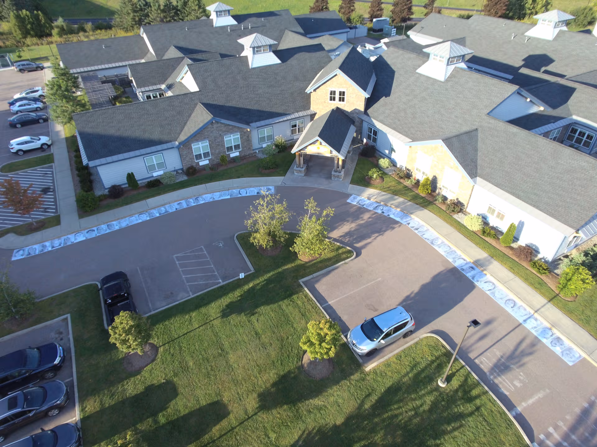 Aerial view of Maple Ridge Lodge Assisted Living exterior with curved drive and parking.