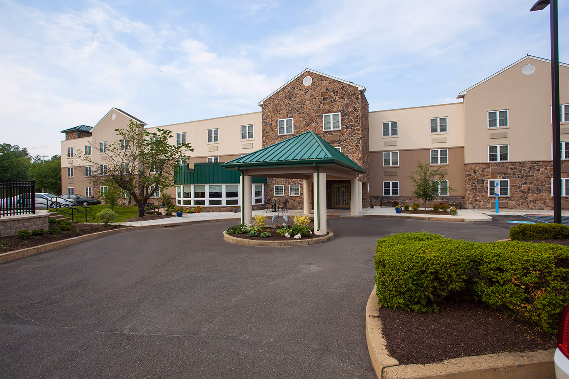 Exterior view of Commonwealth Senior Living at Willow Grove showing the building entrance, canopy, and parking.