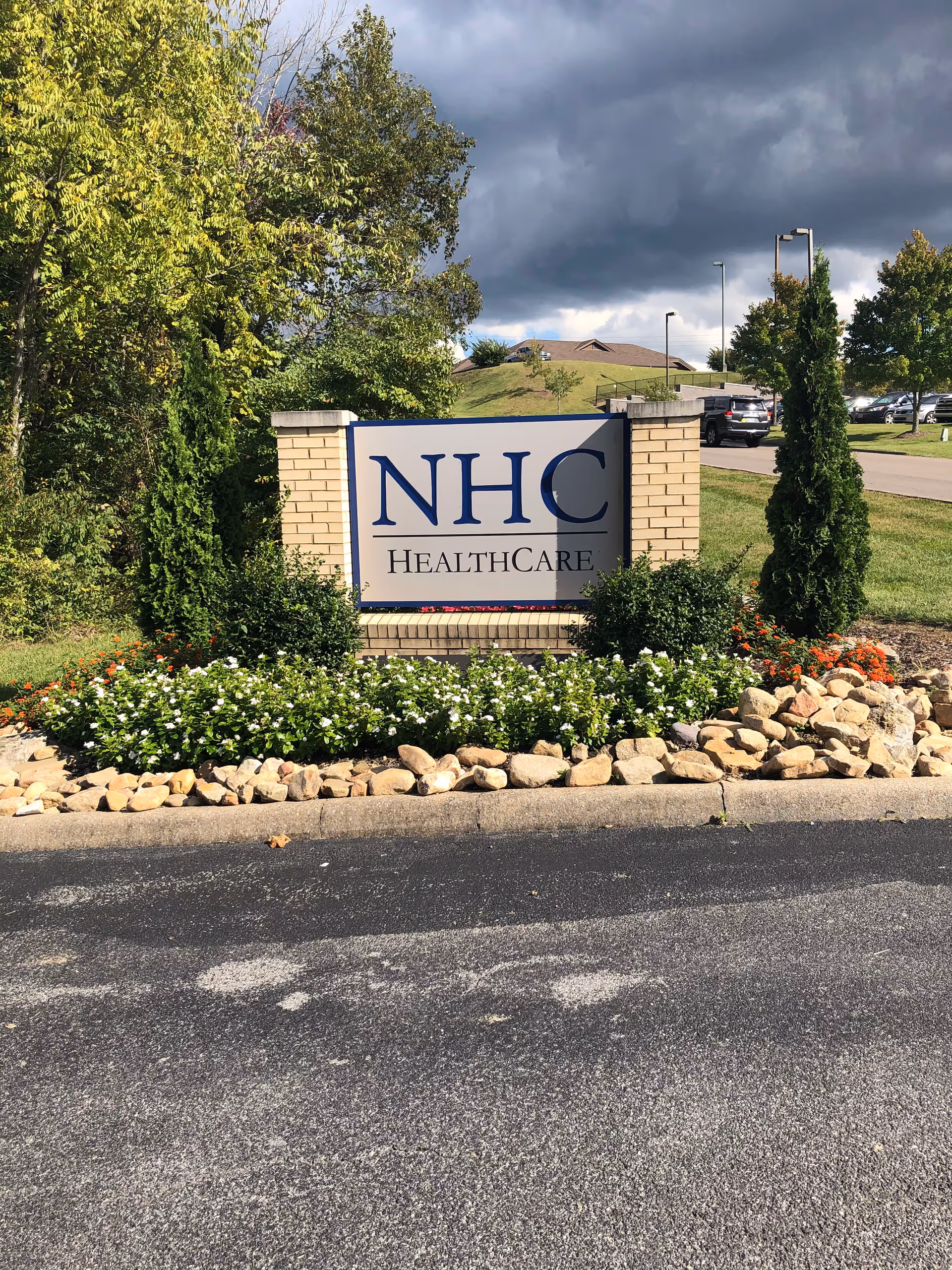 NHC Healthcare sign on brick pillars with landscaped surroundings