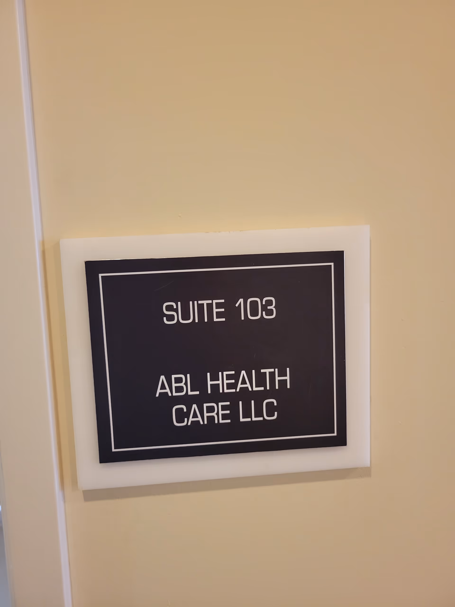 A wall-mounted sign reads 'Suite 103' and 'ABL Health Care LLC'.
