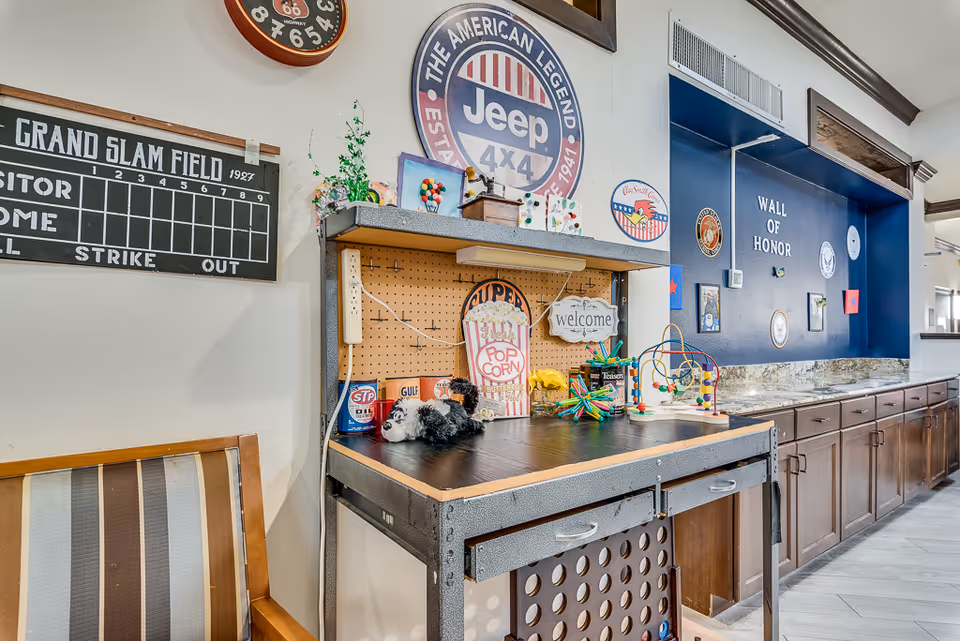 Indoor recreation area with pegboard workbench, vintage signs, and Wall of Honor display.