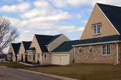Row of townhouse-style senior living buildings with attached garages and lawns.