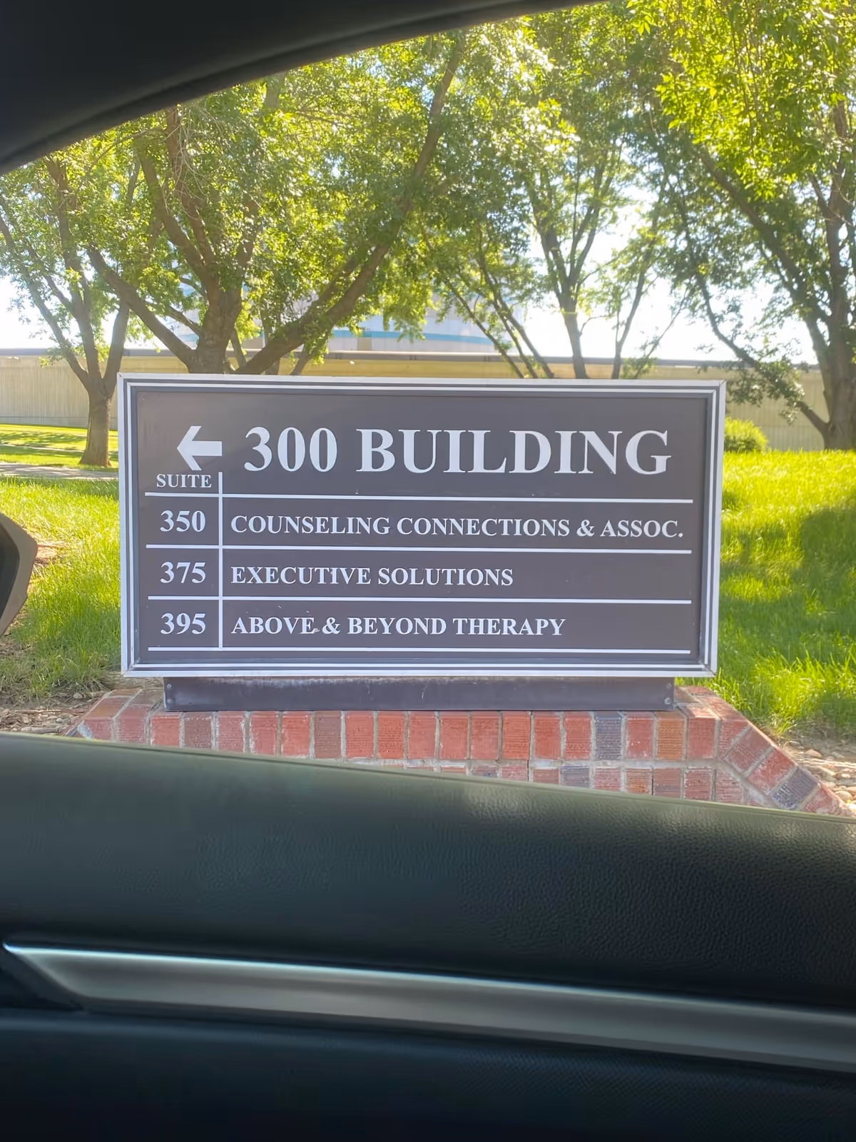 Exterior signboard showing '300 Building' with suite names for therapy services.