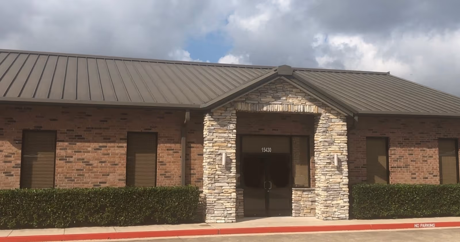 Front view of a brick and stone senior care facility entrance.