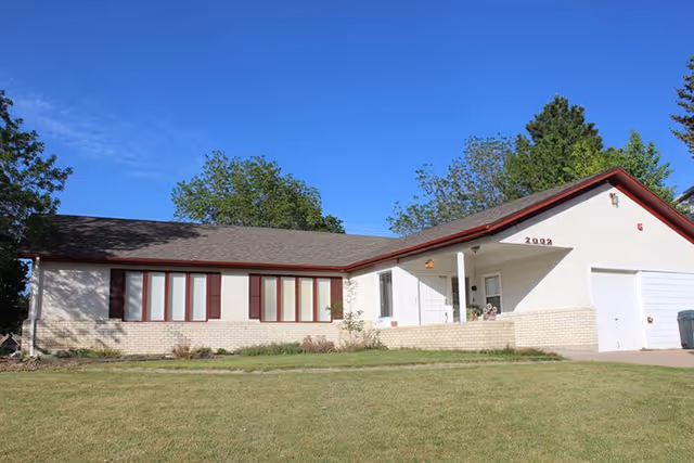 Single-story assisted living facility with front lawn and driveway.