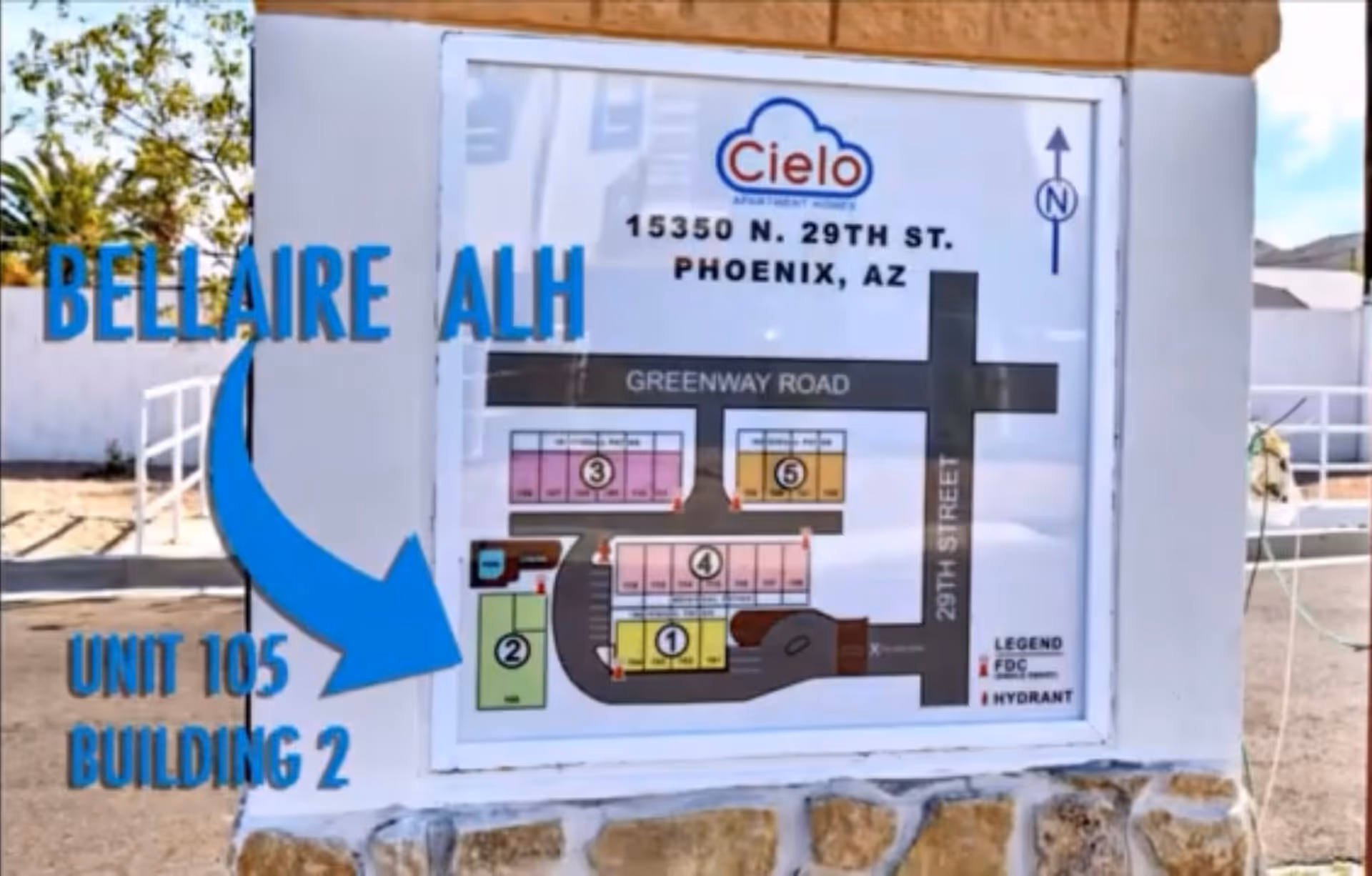 Outdoor site map sign showing the facility address and a blue arrow pointing to Unit 105, Building 2.