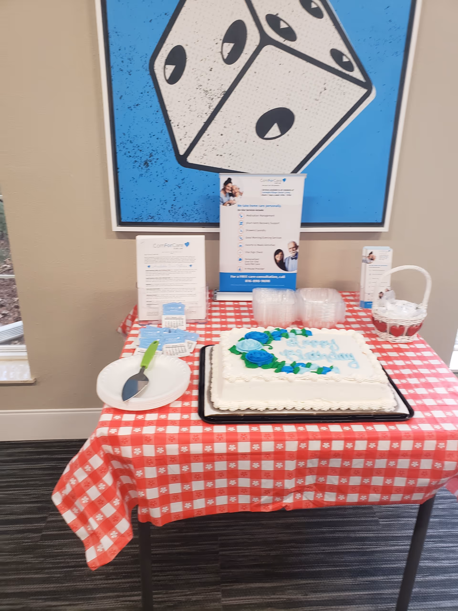 Cake on a red-checkered table with brochures in a room.