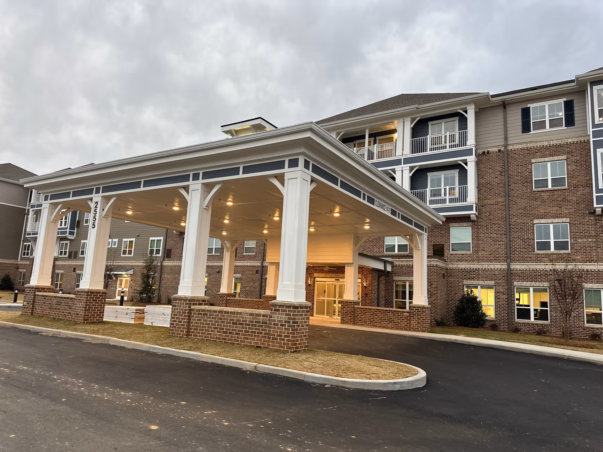 Exterior view of Harmony at Eagles Landing showing a brick building and a covered entrance.