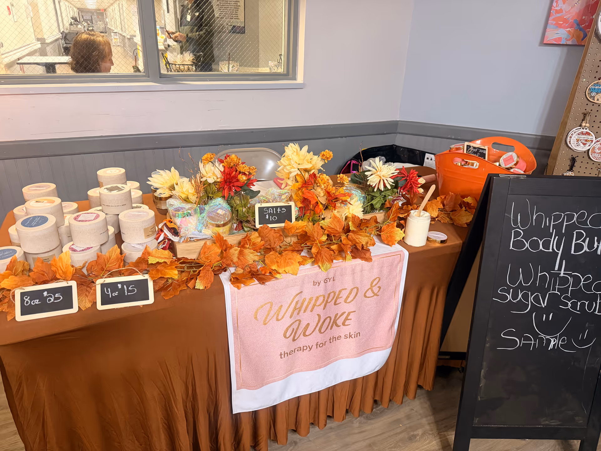 Autumn-themed skincare display on a brown table inside a senior care facility lobby