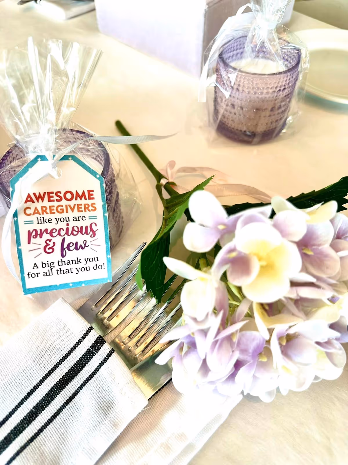 Table setting with flowers, napkin, utensils, and a thank-you tag.