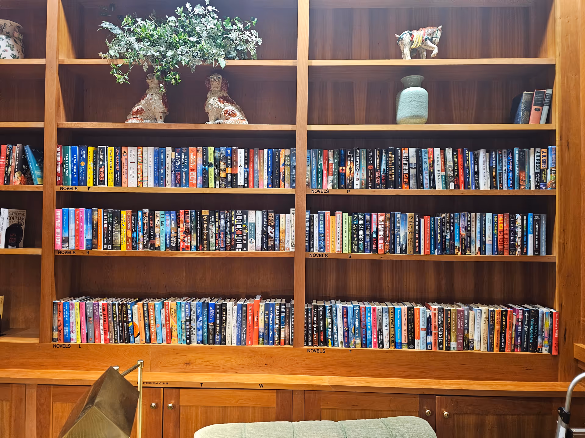 Wooden built-in library shelves filled with colorful books and decorative items.