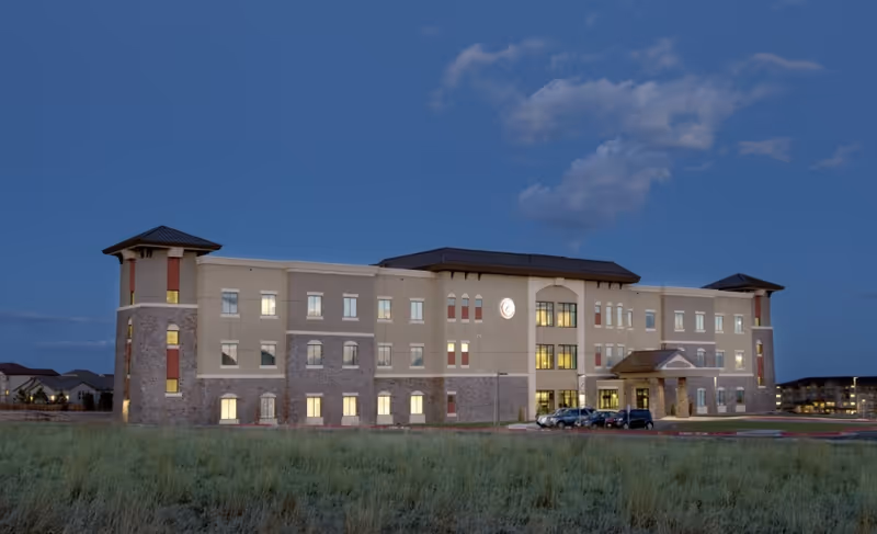 Exterior view of Center at Cordera senior living facility at dusk.