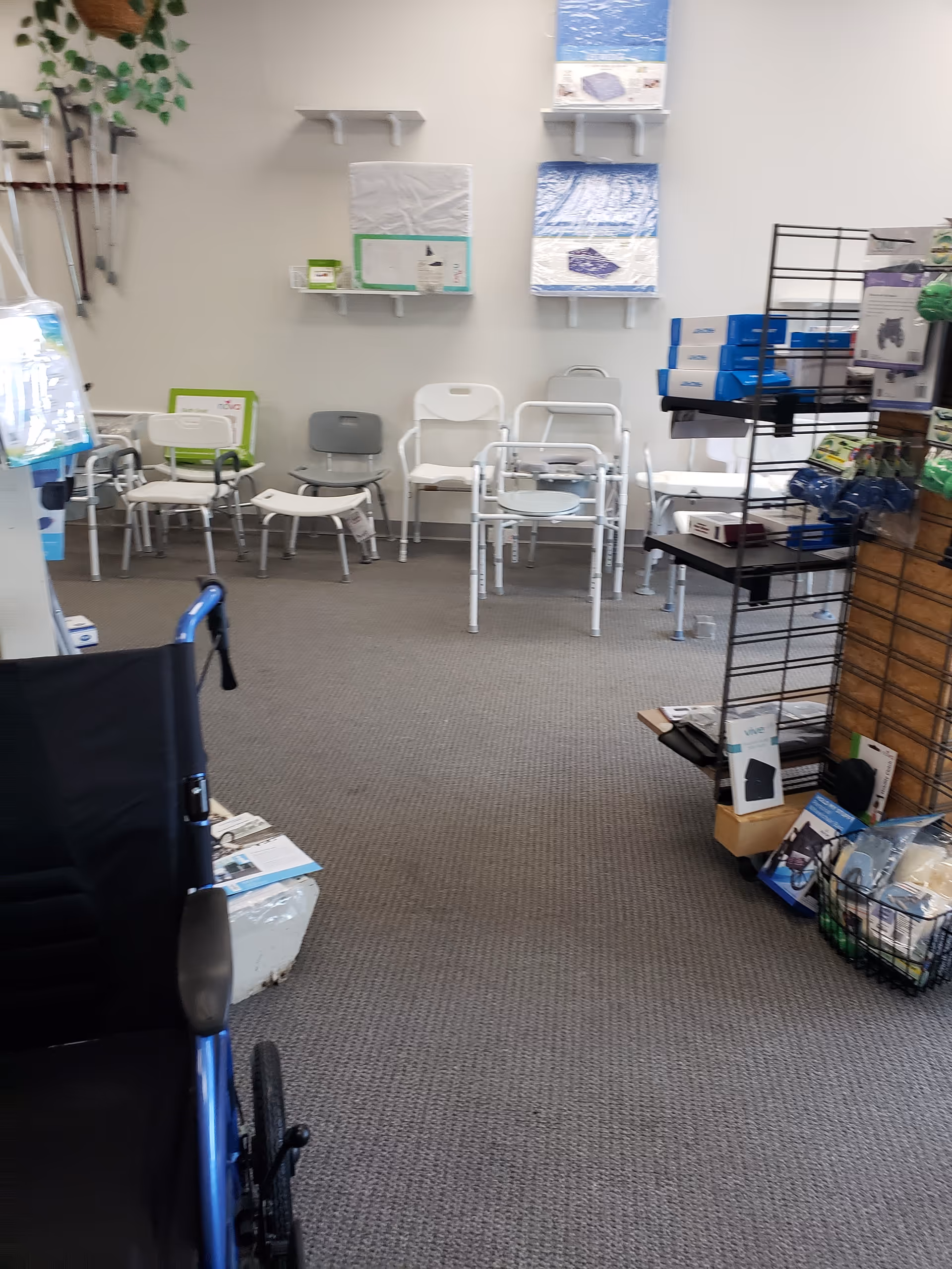 Interior waiting area of a medical supply room with chairs and display racks.