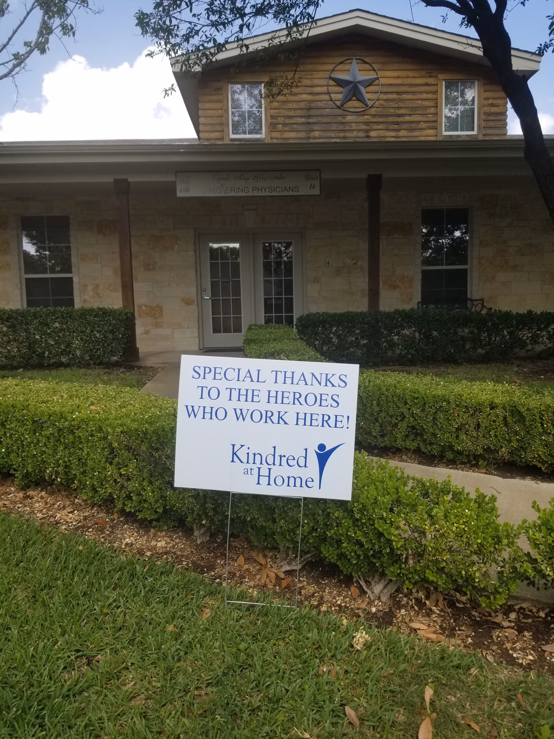 Exterior view of a senior living facility with a tribute sign.