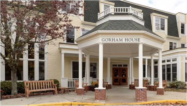 Front view of Gorham House nursing facility with a covered entry and benches