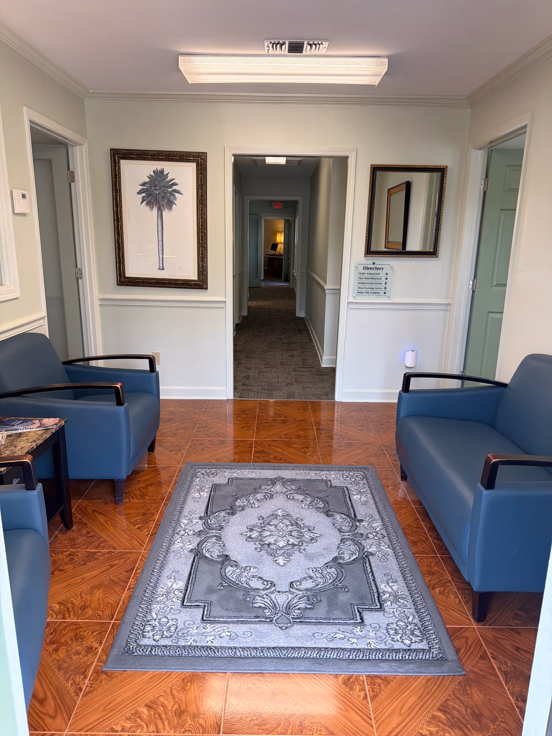 Hallway seating area in a senior living lobby with framed art.
