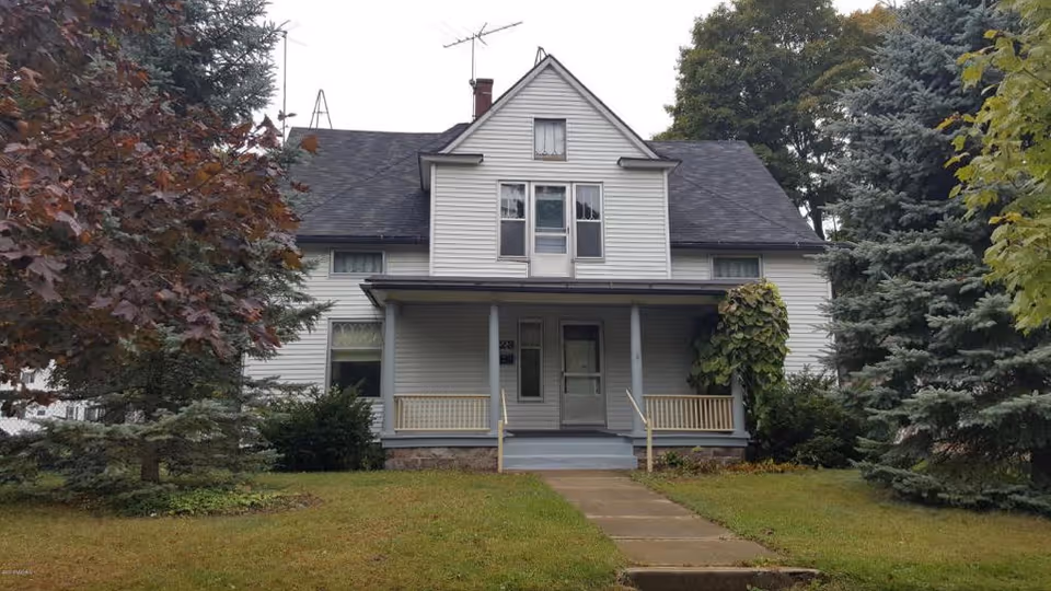 Front view of Pleasant AFC, a two-story white house with a porch and steps.